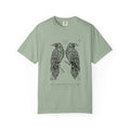 Hávamál tee by Palimpsest — two woodcut ravens above 'cattle die, kinsmen die' in Old Norse, on a sage green garment-dyed shirt