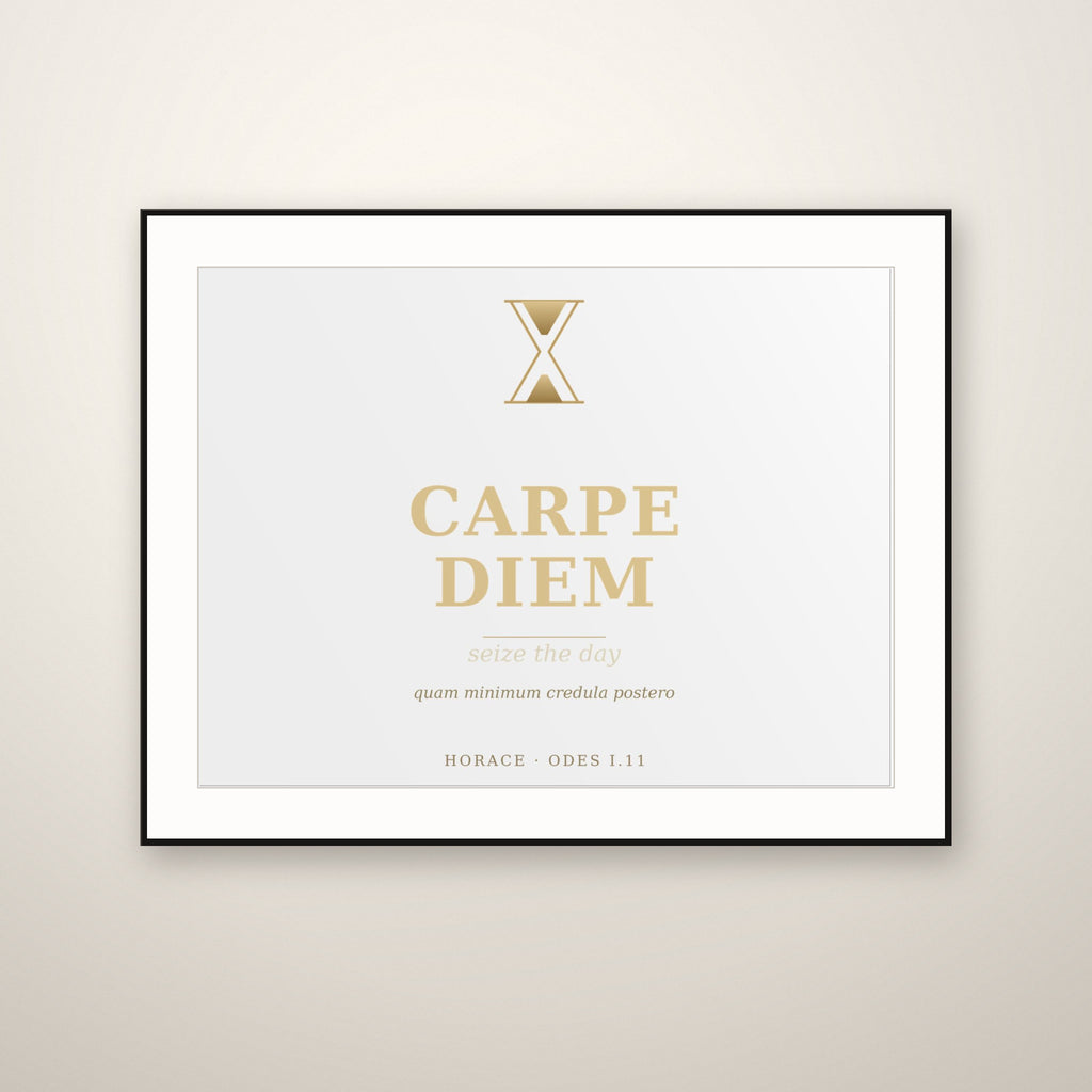 Carpe Diem gold typography print in a thin black frame with a white mat, hung on a warm plaster wall