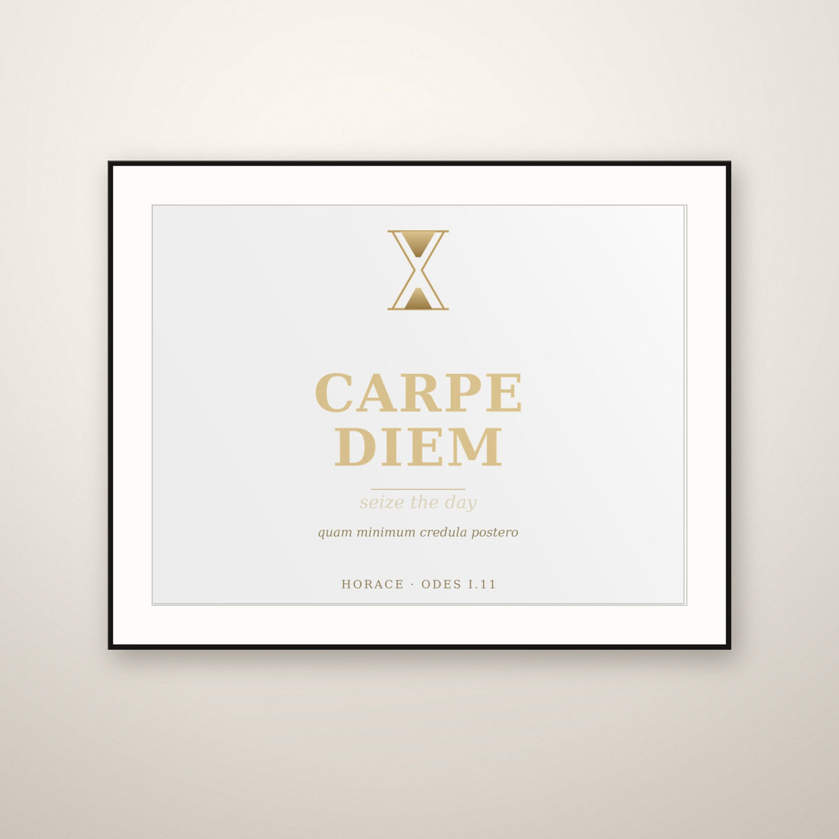 Carpe Diem gold typography print in a thin black frame with a white mat, hung on a warm plaster wall