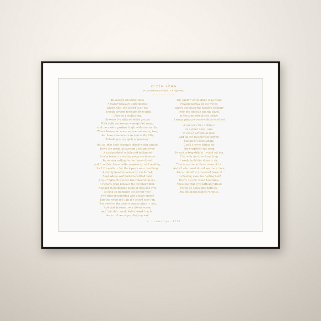 Kubla Khan poem print in a thin black frame with a white mat, hung on a warm plaster wall