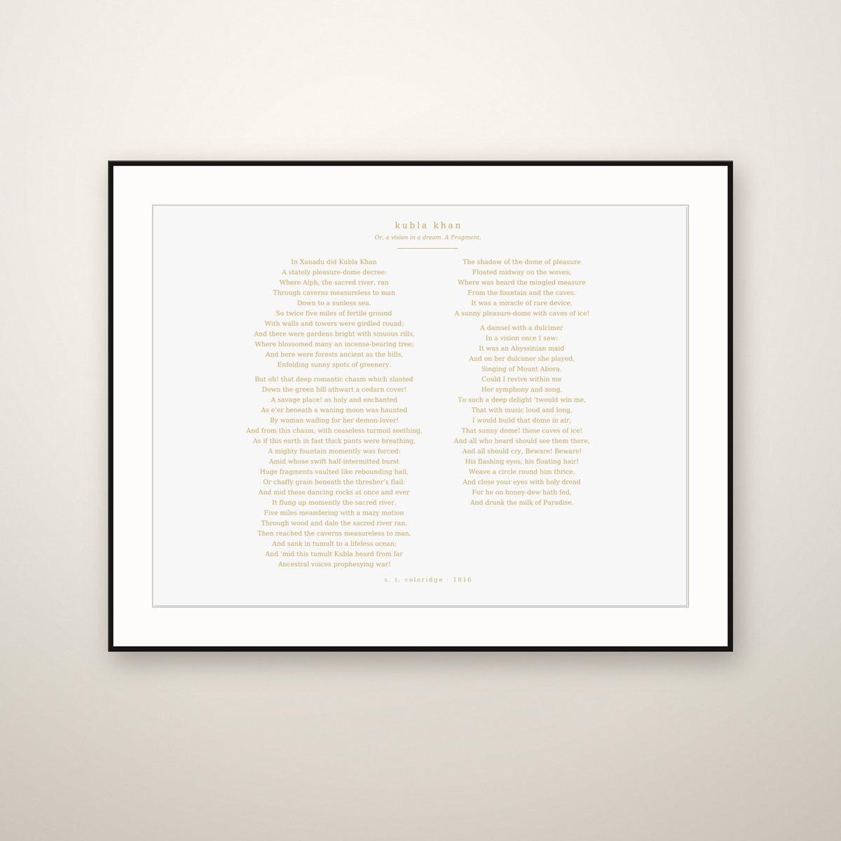 Kubla Khan poem print in a thin black frame with a white mat, hung on a warm plaster wall